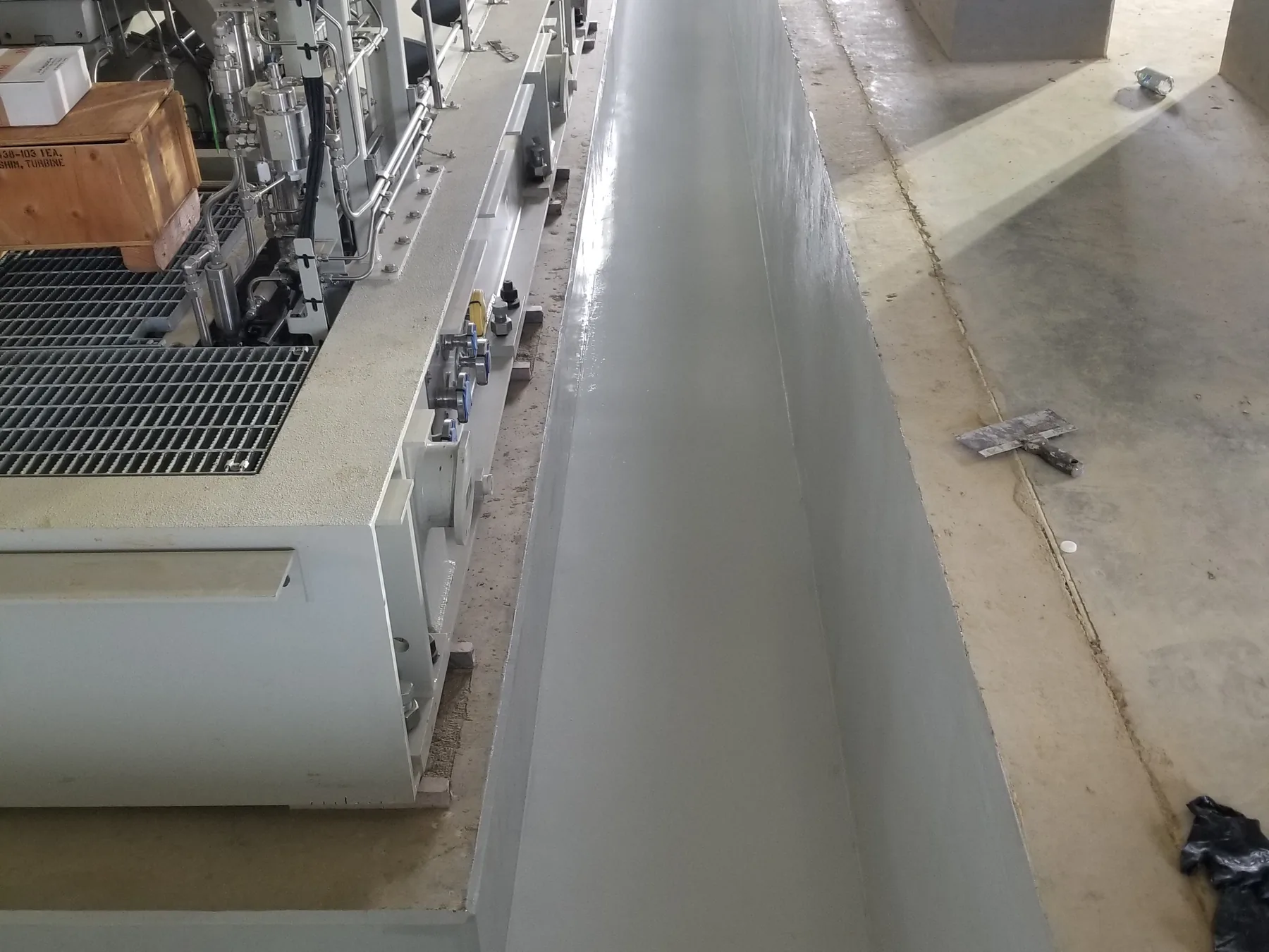 Grey epoxy coated containment trench around plant equipment