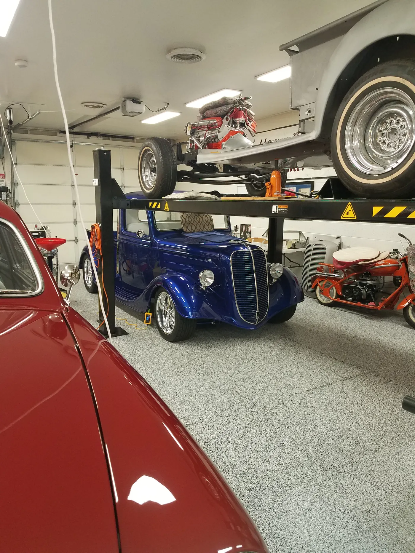 Red classic car on a flake garage floor
