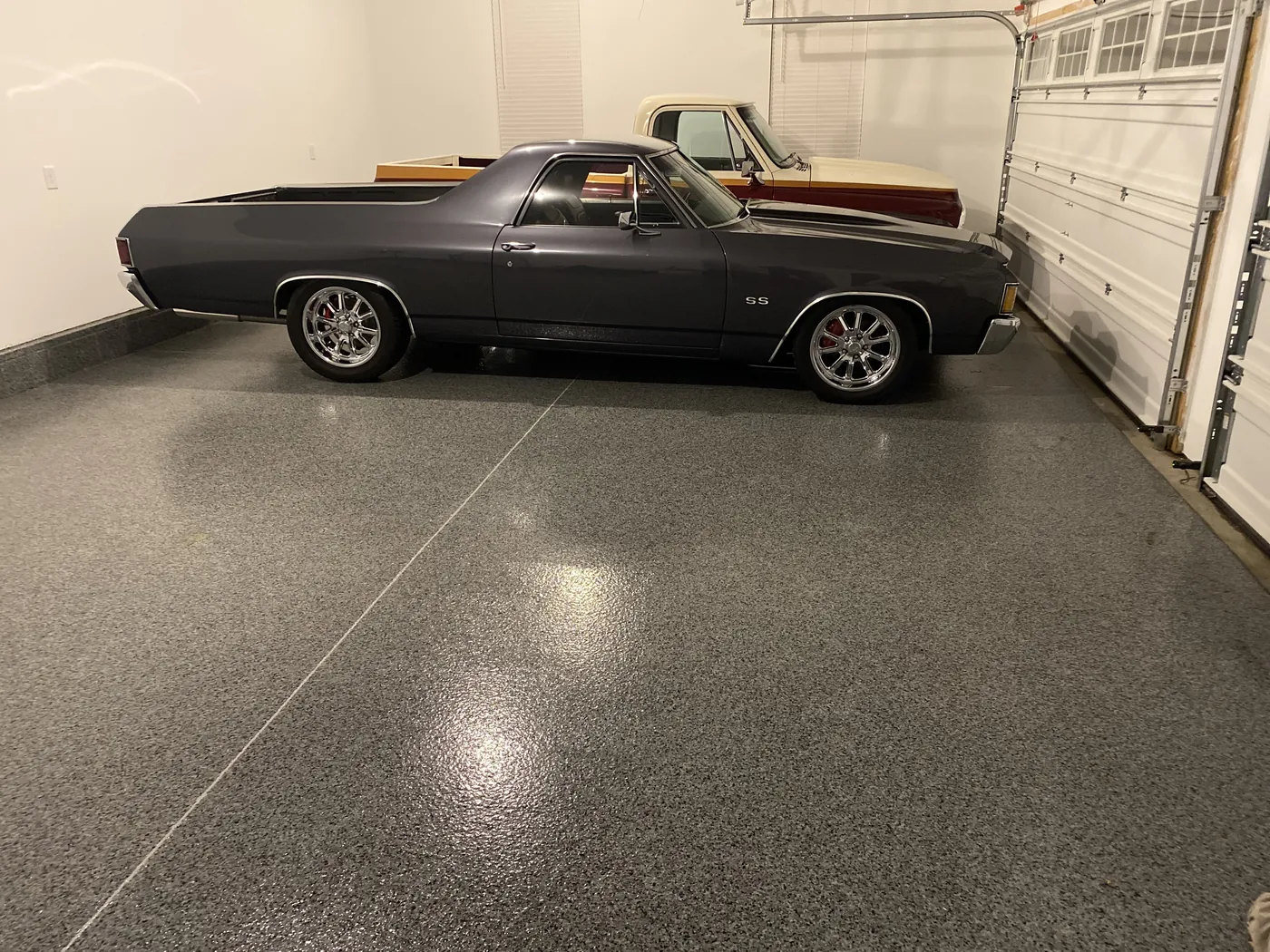 Black classic car on a flake coated garage floor