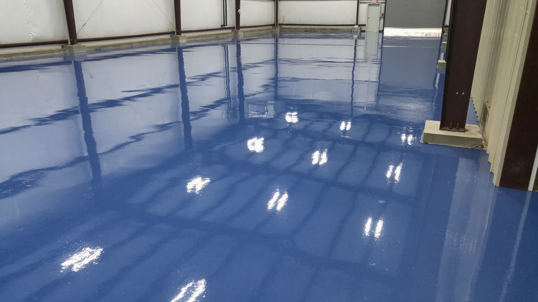 Polished warehouse floor under a blue steel roof
