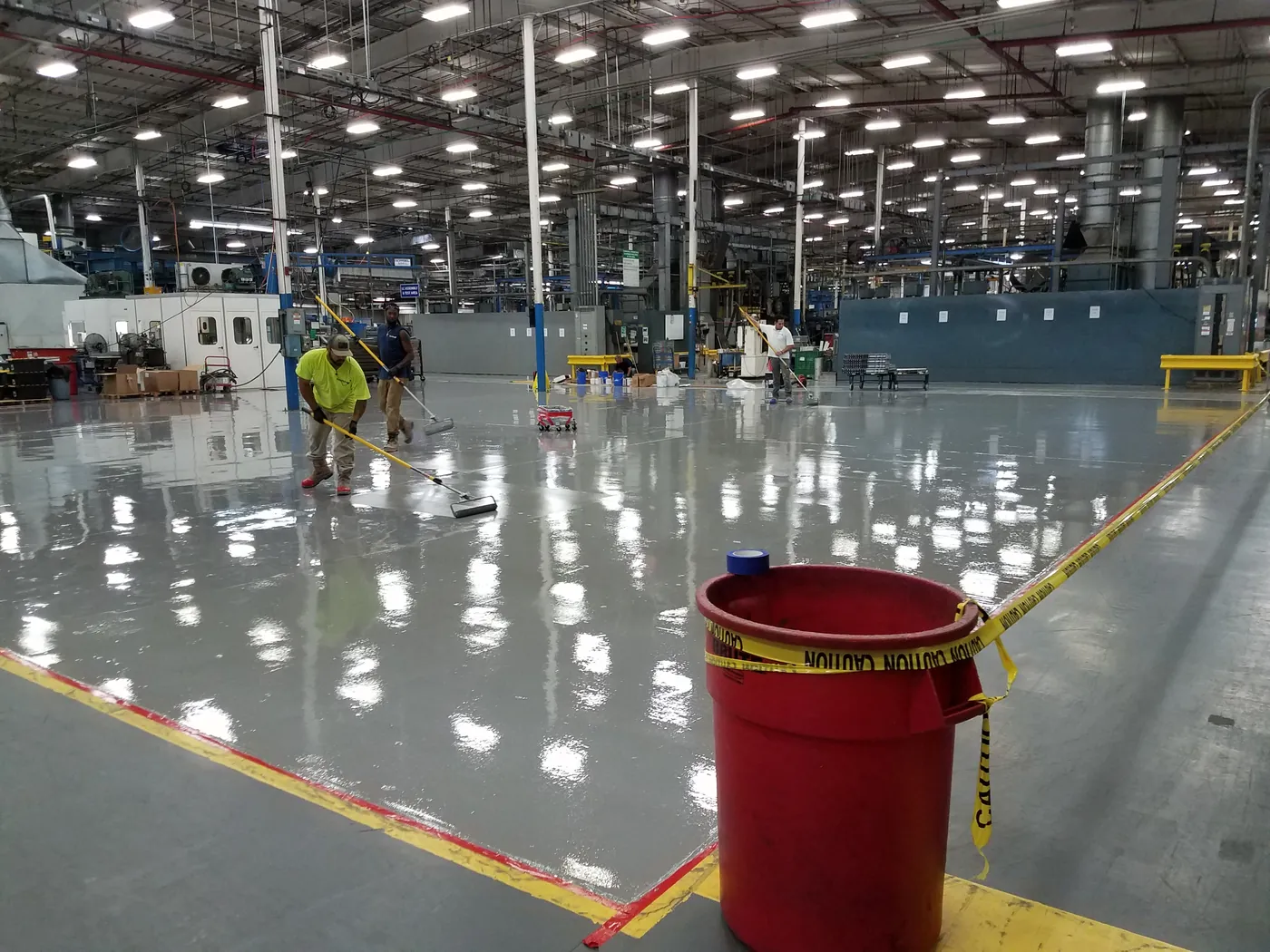 Crew on a coated plant floor with equipment